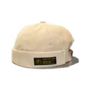 Detail shot of a beige corduroy brimless docker hat with a decorative black patch - Adult 55-58cm / Beige