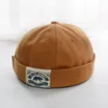 Nahaufnahme der braunen Segeltuch Docker Cap, retro gerollte Miki Mütze mit Frontpatch. - Erwachsene 55-58cm / Camel
