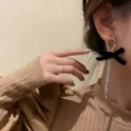 Elegant long silver rhinestone tassel earrings with a chic black velvet bow on a model. - Bowknot Tassel Long Style (E1352) / Silver Plated Black