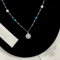Primo piano di una collana con ciondolo a bussola in argento con perle e grani blu - Collana Bussola Blu (R1703)