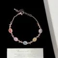 Primer plano de una pulsera de oro rosa con circonitas de colores y adornos de lazos. - Estilo de Lazo Oro Rosa (R1315)
