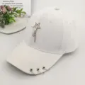 White women's baseball cap featuring a metallic star pendant and iron rings on the brim - White