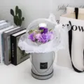 Gros plan d'un bouquet de fleurs de savon dans une boîte cadeau en ballon acrylique - 混搭紫+灯(配袋子)