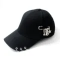 Close-up of a black baseball cap with silver rings on brim and safety pin charms. - Adjustable / Safety Pin Tools Black