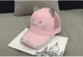 Détail d'une casquette rose à oreilles de chat et strass sur livre - Réglable / Enfant / Style Maille Respirante / Rose