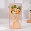 Detailansicht des handgefertigten Häkel-Gänseblümchen-Blumenstraußes in transparenter Geschenkbox. - Mit LED-Licht / Gelbe Puffblume