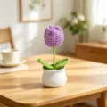 Close-up of a handmade purple crochet tulip in a white pot on a wooden table - Single Head Tulip - Purple