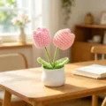 Close-up detail of two pink handmade crochet tulips in a white pot on a sunny wooden table. - Double Head Tulip - Pink