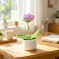Elegant handmade purple crochet flower in white ceramic pot on a sunny wooden desk - Single-Head Rose Potted Plant / Purple