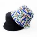 Detail shot of a reversible bucket hat showing black and colorful abstract art printed sides. - Style 9