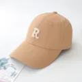 Close-up of a light brown baseball cap featuring a white embroidered letter R detail - Adult 55-59cm / Khaki