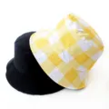 Detail of a yellow checkered and solid black reversible bucket hat on a white background. - Adult 55-58cm / Yellow Cube