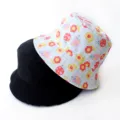 Close-up of double-sided bucket hats in solid black and colorful floral ladybug print. - Adult 55-58cm / Flower