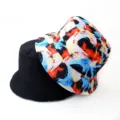 Reversible bucket hat featuring solid black on one side and vibrant abstract print on the other. - Style 21