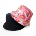 Vue détaillée du chapeau bob réversible avec un imprimé coloré et un côté noir classique. - Style 33