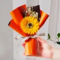 Detail van een mini zonnebloemboeket met gipskruid in een oranje verpakking - Zonnebloem / Oranje Zonnebloem met Gypsophila
