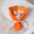 Handmade crochet wool flower bouquet in orange wrapping paper with ribbon, perfect gift. - Orange Wrapping Paper Style
