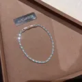 Vista detallada de una pulsera de tenis brillante con degradado azul y blanco en fondo café - Pulsera de Circonia Completa (R5766)