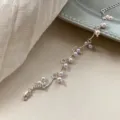 Detalle de una pulsera minimalista de plata con perlas lavanda sobre tela beige suave - Estilo Manta (R2715) / Rosa Claro