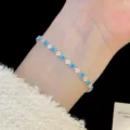 Gros plan d'un délicat bracelet en zircon bleu et transparent porté au poignet - Style Losange (R5580) / Bleu Turquoise