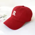 Close-up detail of a red cotton baseball cap with a white embroidered R letter - Adult 55-58cm / Burgundy