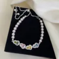 Primer plano de elegante pulsera de perlas con dijes de circonita de colores en forma corazón - R1724 Pulsera Calabaza Manta Colorida