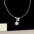 Close-up of silver star and heart necklace charms with sparkling blue zircons and crystals. - Blue Zirconia Star Necklace (R2228)