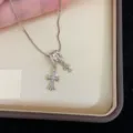 Detailaufnahme einer goldenen Halskette mit Doppelkreuz-Anhänger auf Satinfutter - R1622 Kaffeegold Doppelkreuz Halskette / Kaffeegold Doppelkreuz