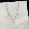 Elegant silver chain necklace featuring translucent blue crystal balls on beige display - Blue Style (R1427)