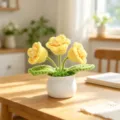 Detailed view of handmade crocheted yellow flowers in a white pot on a wooden table - 3-Head Lily of the Valley - Yellow