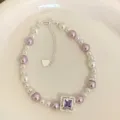 Vista dettagliata di un elegante bracciale di perle viola e bianche con gemma quadrata - Stile Gemma a Rombo (R5392) / Viola