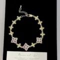 Vista macro dettagliata di un lussuoso bracciale vintage in oro con fiori viola - Bracciale Fiore a Quattro Foglie (R2521) / Viola