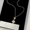 Detailed close-up of a French retro gold necklace featuring a sparkling pink and white floral pendant - Four-leaf Flower Necklace (R2159)