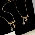 Primer plano del collar imperdible retro con dijes de cruz y circonita en forma de gota. - Collar de Alfiler de Cruz (R2195)