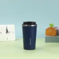 Vorderansicht eines mattblauen Edelstahl-Thermobecher für Kaffee auf einem Schreibtisch - 380ml / Blau