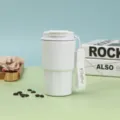 Detailansicht des weißen isolierten Kaffeebechers mit Trageriemen und Kaffeebohnen Requisite. - Weiß