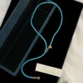 Elegante collana di perline turchesi con chiusura a levetta dorata e nappa - Collana di Perline Pendente Capsula di Loto (R5729)
