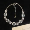 Elegante pulsera con acabado plateado con cristales ovalados azules y brillantes tréboles - Estilo de Trébol de Cuatro Hojas Azul Cielo (R5551)