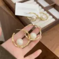 Eleganti orecchini a cerchio dorati con perla centrale per un look femminile e raffinato - Stile Perla / Oro