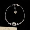 Pulsera elegante de plata con circón azul ovalado y dije de corazón sobre fondo negro - Estilo de Piedra Única Ovalada (R2059) / Azul cielo