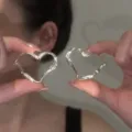 Eleganti orecchini a cerchio a forma di cuore color argento con texture brillante - Stile Cerchio a Cuore / Argento