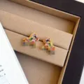 Exquisite Nahaufnahme von bunten Zirkon-Pony-Ohrringen in einer luxuriösen beigen Schmuckschatulle - R5810 Bunte Zirkonia Pferd Ohrstecker