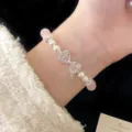 Elegante braccialetto con cristalli rosa, perle bianche e un fiocco di cristallo. - Bracciale Con Fiocco Di Strass Rosa E Perline (R2790)
