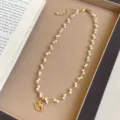 Detailansicht eines Schaukelpferd-Anhängers an einer eleganten Perlen- und Goldkette. - R2223 Schaukelpferd Perlenkette