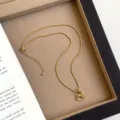 Detailaufnahme einer goldenen Schaukelpferd-Halskette mit strukturierter Kette. - R1812 Schaukelpferd Anhänger Halskette