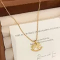 Vista ravvicinata di una collana con pendente a cavallo a dondolo dorato e trama unica - R0318 Collana con Ciondolo a Cavallo a Dondolo