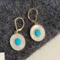 Elegant gold dangle earrings featuring turquoise and mother of pearl oval pendants with halos - Shell Ear Buckle