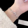 Elegante bracciale a catena argentato con ciondoli a stella e luna molto scintillanti. - Bracciale Stella Luna (R1032)