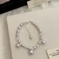 Elegant light purple pearl bracelet with silver spacers and charms on a beige display - Manta Bubble Style (R5759) / Pale Purple