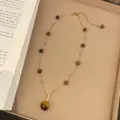 Detailed shot of a vintage gold necklace featuring natural tiger eye pendant and beads. - Retro Gold Large Bead Tiger's Eye Necklace (R0238)